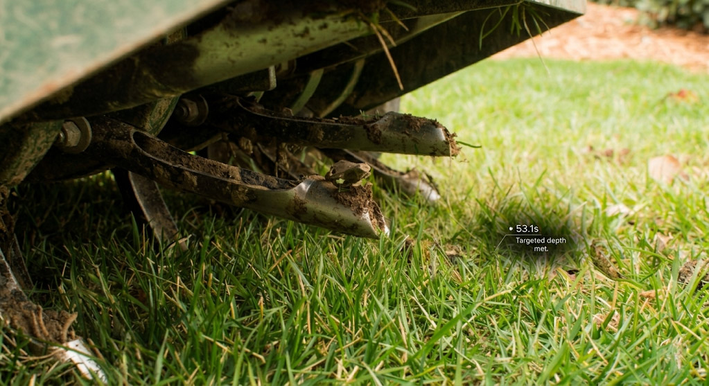 Professional core aeration machine pulling plugs of dirt from a compacted lawn in Willowdale, Toronto
